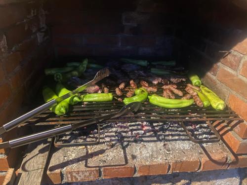 a bunch of peppers and meat on a grill at Edelweiss Villa Trpejca in Ohrid