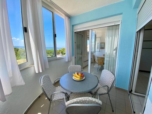 a dining room with a table and chairs and windows at 2 bedrooms apartment with sea view in Baška Voda