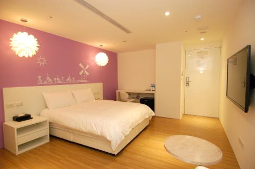 a bedroom with a white bed and a purple wall at Season 5 Inn in Luodong