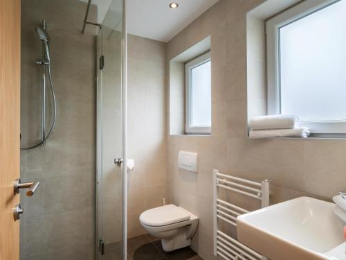 ein Bad mit einer Dusche, einem WC und einem Waschbecken in der Unterkunft Appartements Pungg in Fügen