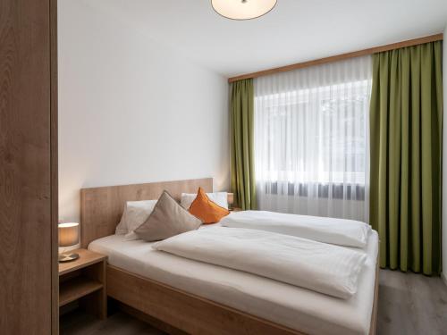 een slaapkamer met een groot bed en een raam bij Appartements Pungg in Fügen