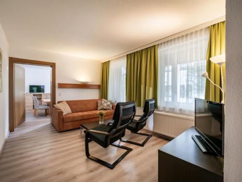 a living room with a couch and a table and chairs at Appartements Pungg in Fügen