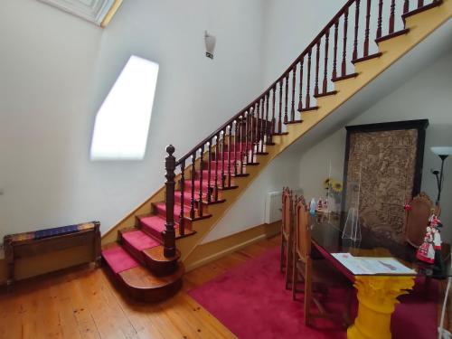 a room with a staircase with a table and chairs at A Vianesa - Guest House in Viana do Castelo