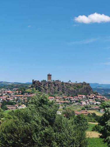a castle on top of a hill with trees at Chez Serge et Annie in Polignac