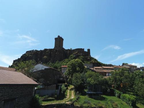 ein Schloss auf einem Hügel mit Häusern in der Unterkunft Chez Serge et Annie in Polignac