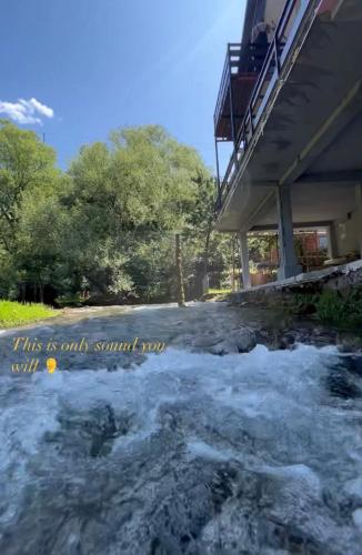 ein Fluss mit Schnee auf dem Boden neben einem Gebäude in der Unterkunft Kuća na vodi Ilma in Kulen Vakuf