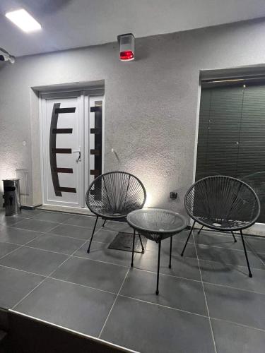 two chairs and a table in front of a door at Edelweiss Villa Trpejca in Ohrid