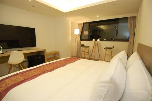 a hotel room with a bed and a television at Season 5 Inn in Luodong