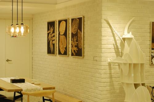 a room with a white brick wall with a table and chairs at Season 5 Inn in Luodong