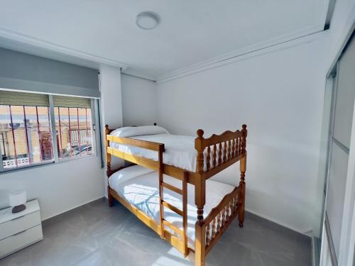 a bedroom with two bunk beds and a window at Paradise Sol Apartamento en Los Alcázares in Los Alcázares