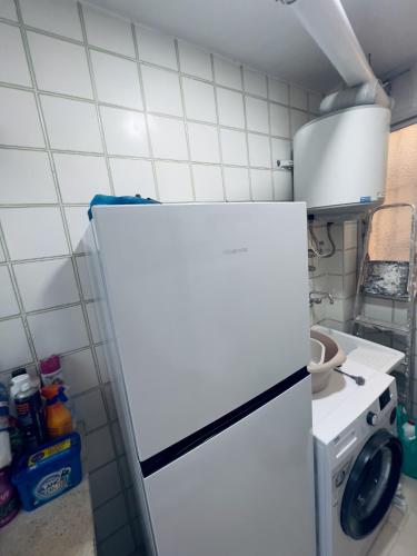 a white refrigerator in a kitchen with a stove at Paradise Sol Apartamento en Los Alcázares in Los Alcázares