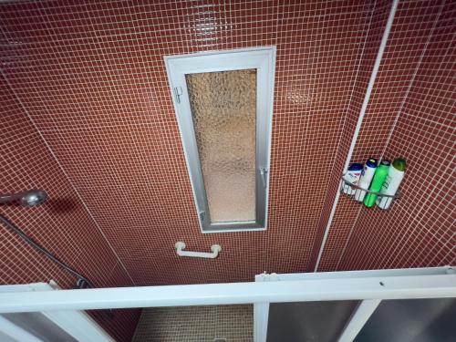 a bathroom with a red tiled wall with a mirror at Paradise Sol Apartamento en Los Alcázares in Los Alcázares