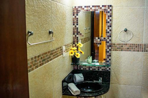 a bathroom with a sink and a mirror at Castelo Beach Hotel in Natal