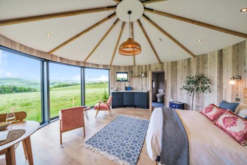 a bedroom with a large bed with a large window at The Roundhouses in Alnwick