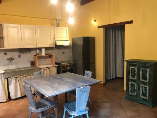 a kitchen with a table and chairs and a refrigerator at Dependance - Casa delle rondini in Carignano