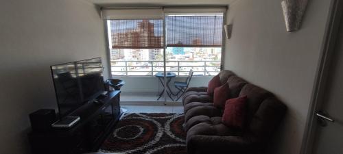 a living room with a couch and a television at Iquique, ED. MATIZ CAVANCHA in Iquique
