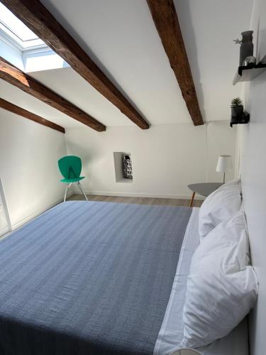 1 dormitorio con 1 cama y 1 silla verde en CasaNico, en Trieste
