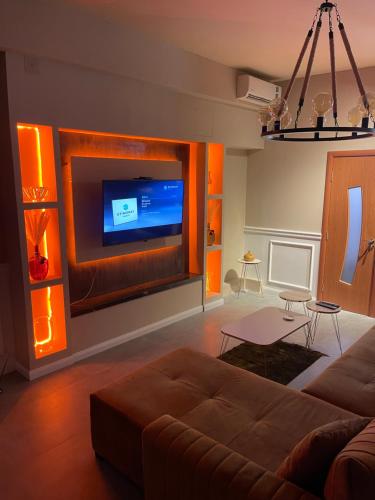 a living room with a couch and a flat screen tv at Mystique Spa Apartment in Belgrade