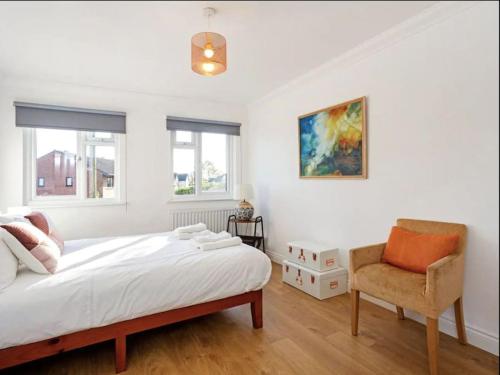 a white bedroom with a bed and a chair at Winchester Nest in Winchester