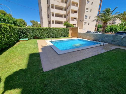a swimming pool in a yard next to a building at OLGAPARTMENT in Miami Platja
