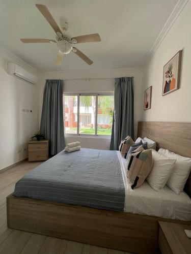 a bedroom with a large bed with a ceiling fan at Casa Mulata Coral Village Pool & Playa in Punta Cana