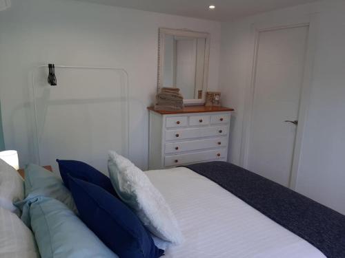 a bedroom with a bed with a dresser and a mirror at R Gem by the Sea in Vélez-Málaga
