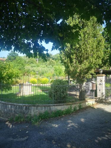 a fence with a tree in front of a cemetery at Casa Raffaello in Castiglione dʼOrcia