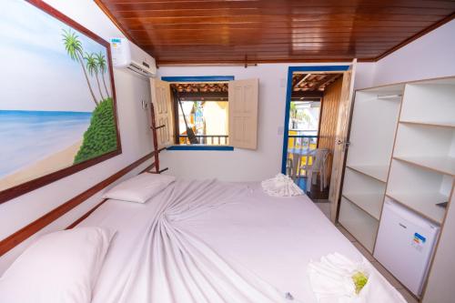 um pequeno quarto com uma cama e uma janela em Brisa do Caitá Praia Hotel em Morro de São Paulo