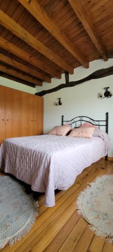 ein Schlafzimmer mit einem Bett und einer Holzdecke in der Unterkunft CASERIO EL AJO in Santillana del Mar