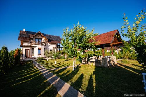 a house with a grassy yard next to a house at Casa Dora in Suceava