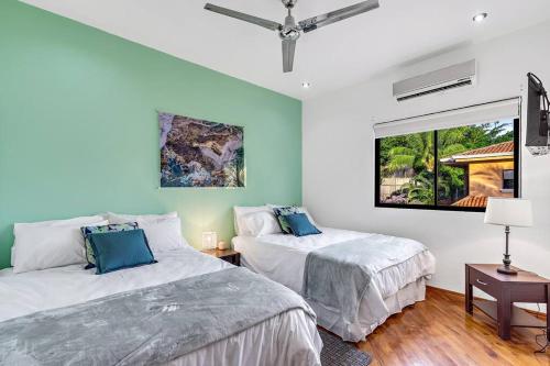 two beds in a room with a window at Casa Mojito~Serene 2 bedroom with prime location! in Tamarindo