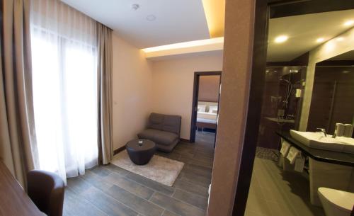 La salle de bains est pourvue d'une chaise, d'un lavabo et d'un miroir. dans l'établissement Hotel Mostar, à Mostar