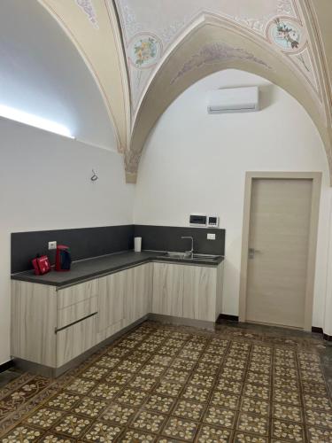 einen Torbogen in einer Küche mit einem Waschbecken und einer Tür in der Unterkunft B&B Lecce26 in San Pietro Vernotico