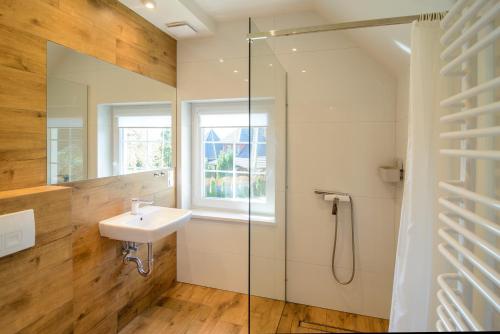 a bathroom with a sink and a glass shower at Pensjonat Srebrny Klon in Bytów