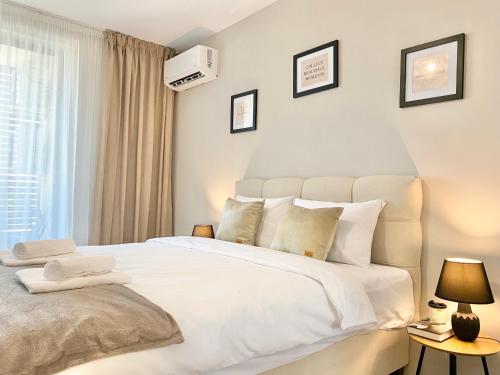 - une chambre avec un grand lit blanc et des oreillers blancs dans l'établissement Comfort & Classy 1Bed Аpartment for 4 Guests, à Plovdiv