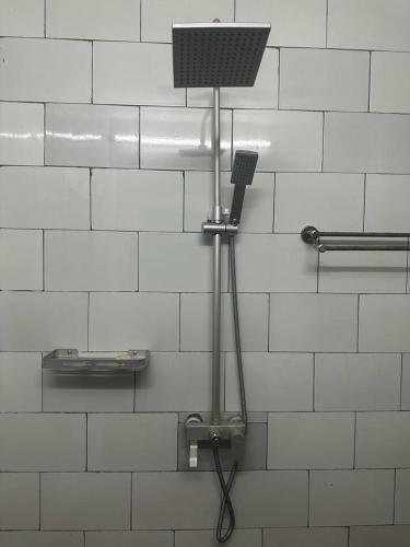 a shower in a bathroom with a hair dryer on a wall at Ifson Home_1 in Kankamsen