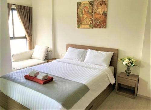a bedroom with a large bed and a chair at Deluxe Pool View La Casita Hua Hin Managed By Asiabb in Hua Hin