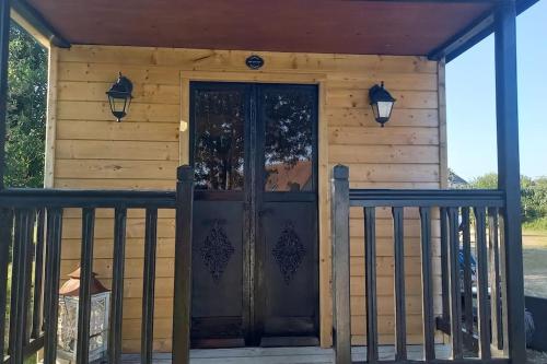 a front door of a wooden house with two lights at La Bohème in Surville