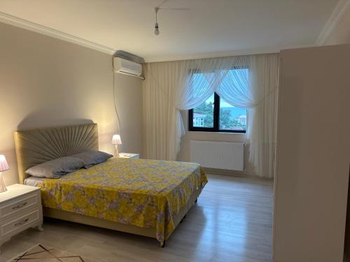 Schlafzimmer mit einem Bett und einem Fenster in der Unterkunft BLUE FEAST GARDEN KONAKÖNÜ in Araklı