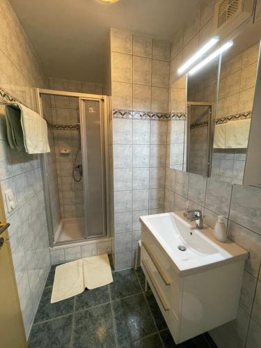 La salle de bains est pourvue d'un lavabo et d'une douche. dans l'établissement Haus Krismer, à Radstadt