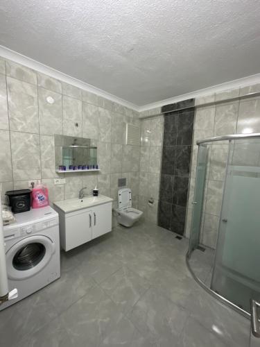 ein Bad mit einer Dusche und einer Waschmaschine in der Unterkunft BLUE FEAST GARDEN KONAKÖNÜ in Araklı