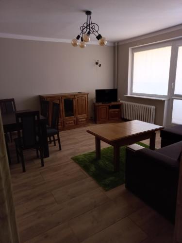 uma sala de estar com uma mesa e um sofá em Apartament 7 Piętro em Bydgoszcz