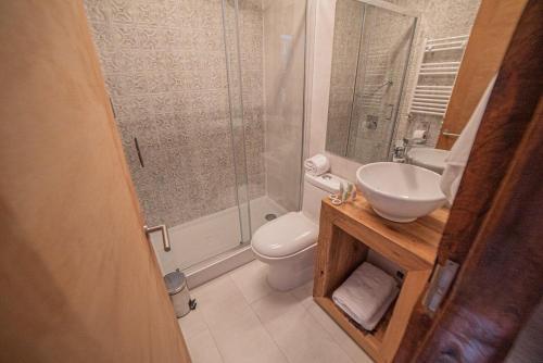 een badkamer met een toilet, een wastafel en een douche bij Hotel Vivo Montaña in Pinto