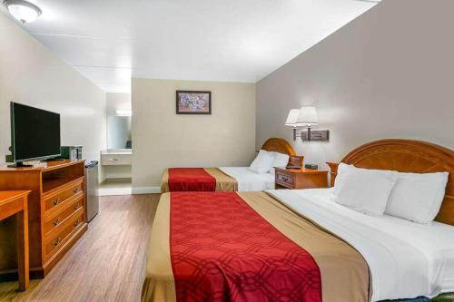 ein Hotelzimmer mit 2 Betten und einem Flachbild-TV in der Unterkunft King's Inn Motel in Reading