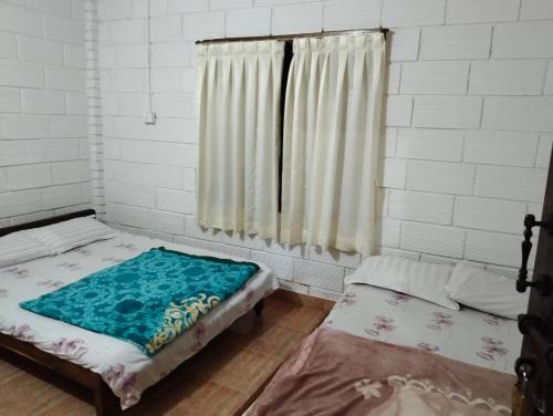 a room with two beds and a window at Nature Valley Homestay Near Annapoorneshwari Temple in Kalasa