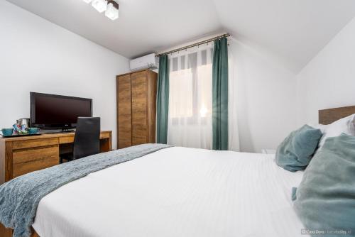 a bedroom with a bed and a desk with a television at Casa Dora in Suceava