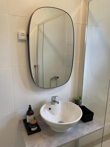 een badkamer met een witte wastafel en een spiegel bij Cantinho da Rosa - Terras de Bouro in Terras de Bouro