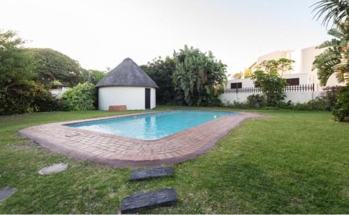 - une piscine dans une cour avec un kiosque dans l'établissement Ballito Shores Simbalina " Family-oriented ", à Ballito