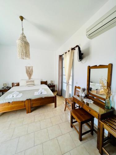 a bedroom with a bed and a mirror and a table at Kirki Rooms on the Hill in Parikia