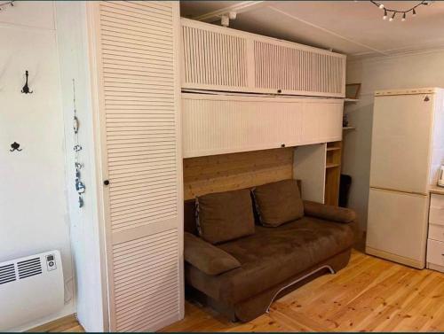 a living room with a brown couch in a room at Domek letniskowy Pogorzelica in Pogorzelica